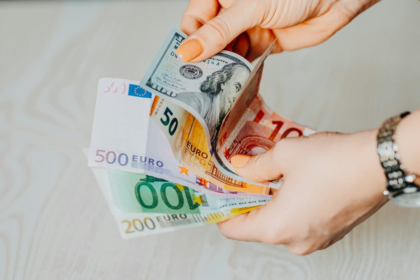 Hands counting euro and US dollar banknotes