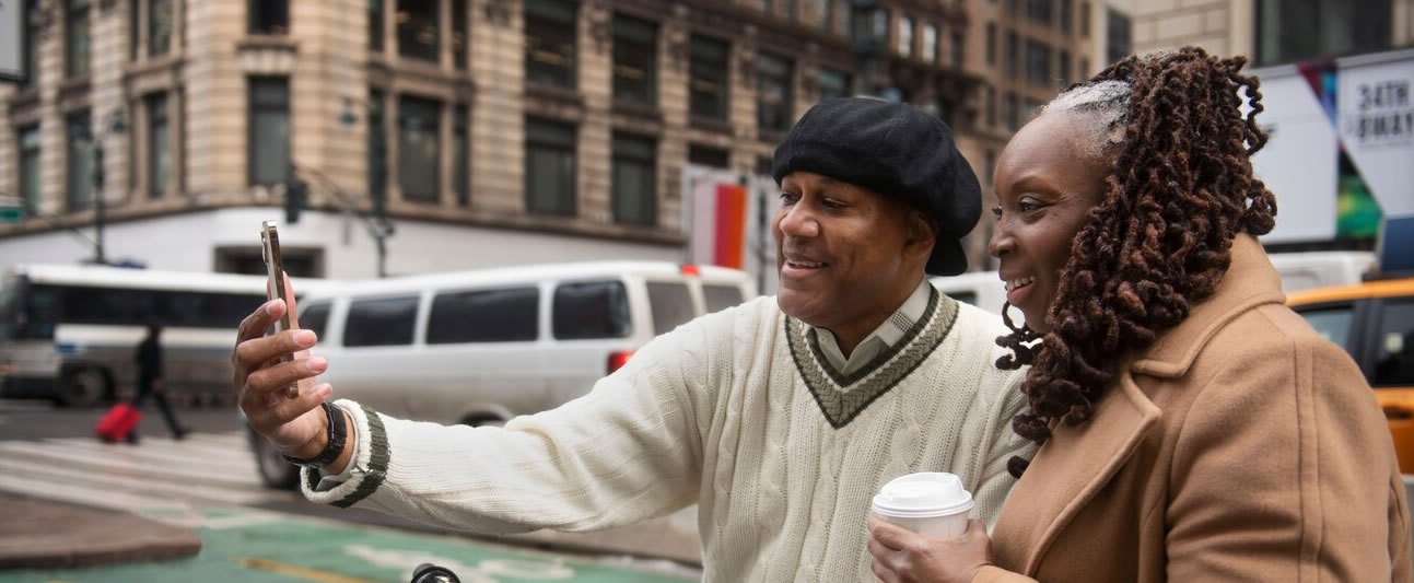 A couple taking a selfie together on a busy city street abroad