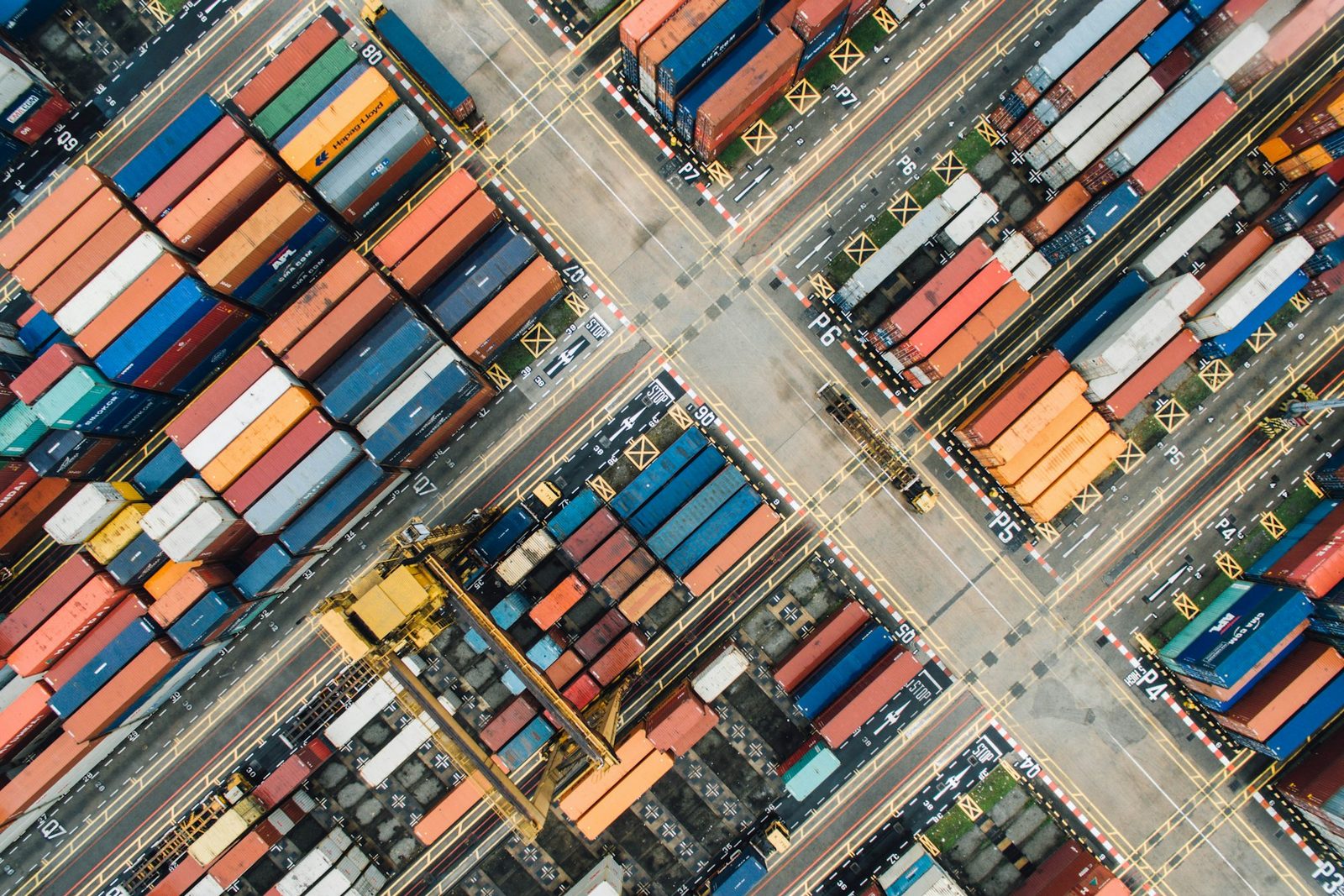 An aerial view of a container terminal with stacks of shipping containers